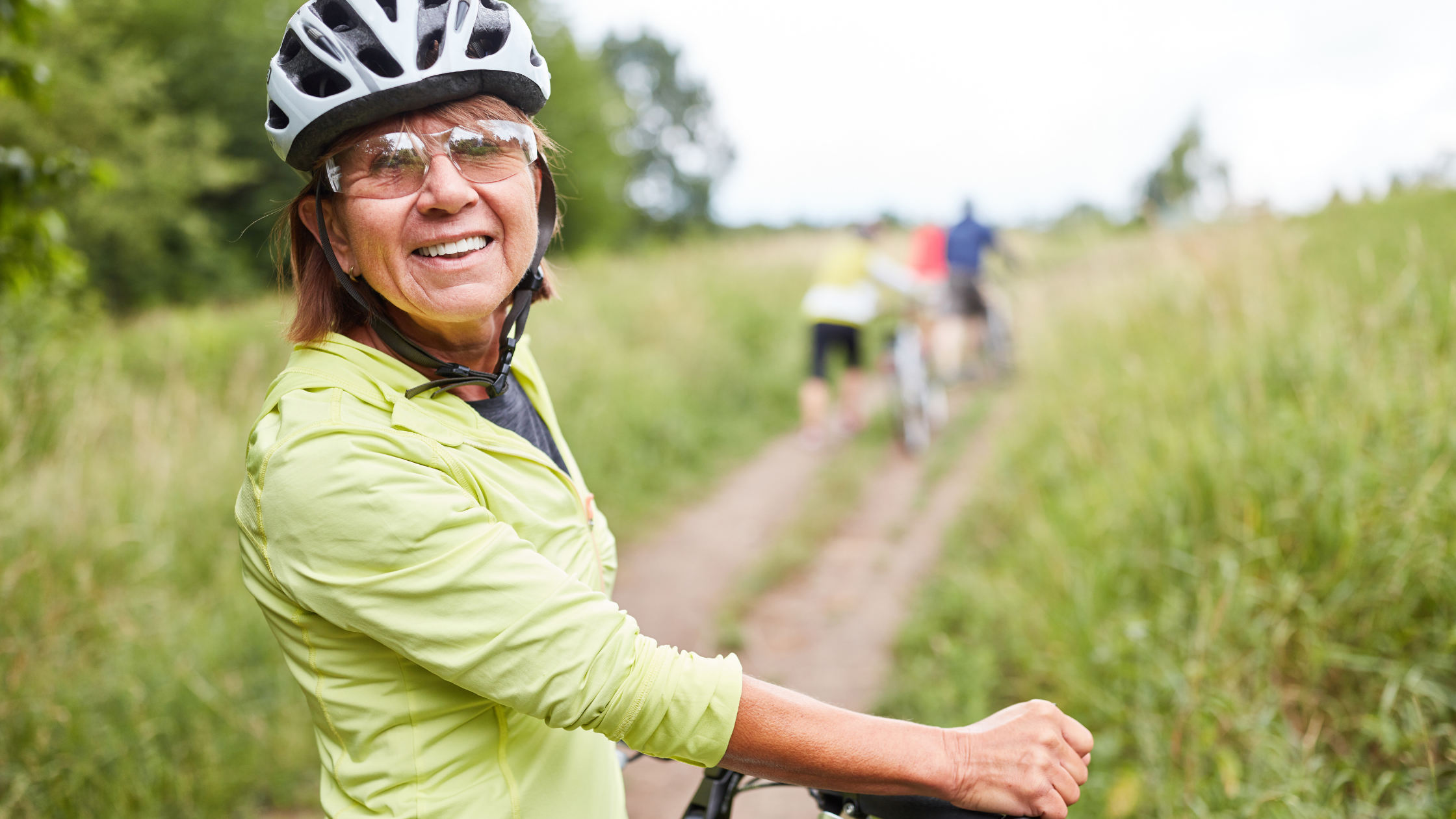 mature female on bicycle in field