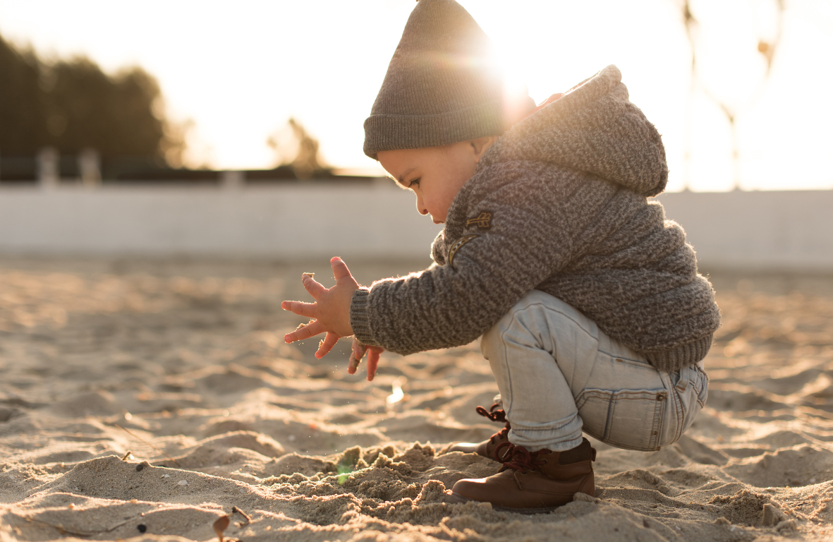 Young boy discovering sand