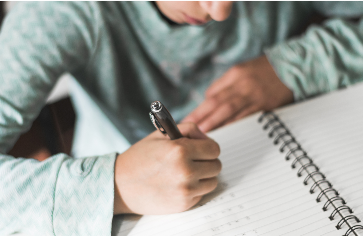 boy writing in an exercise book