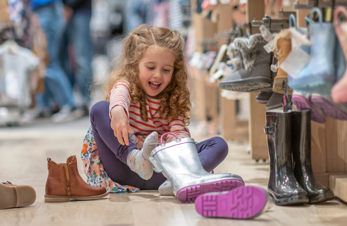 young girls tryinging on various shoe styles in store